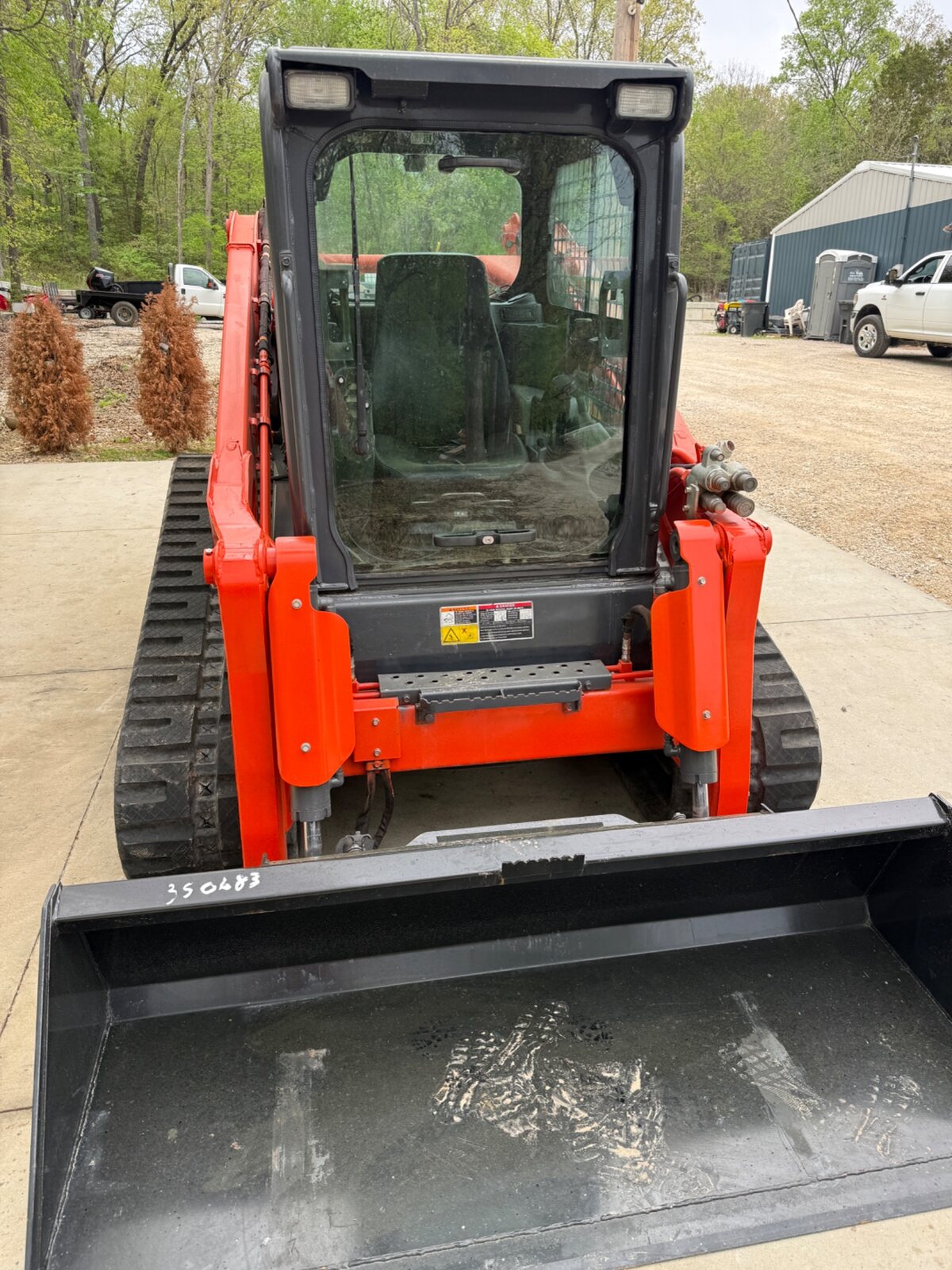 Front view of the Kubota SVL97-2 enclosed cab and smooth bucket
