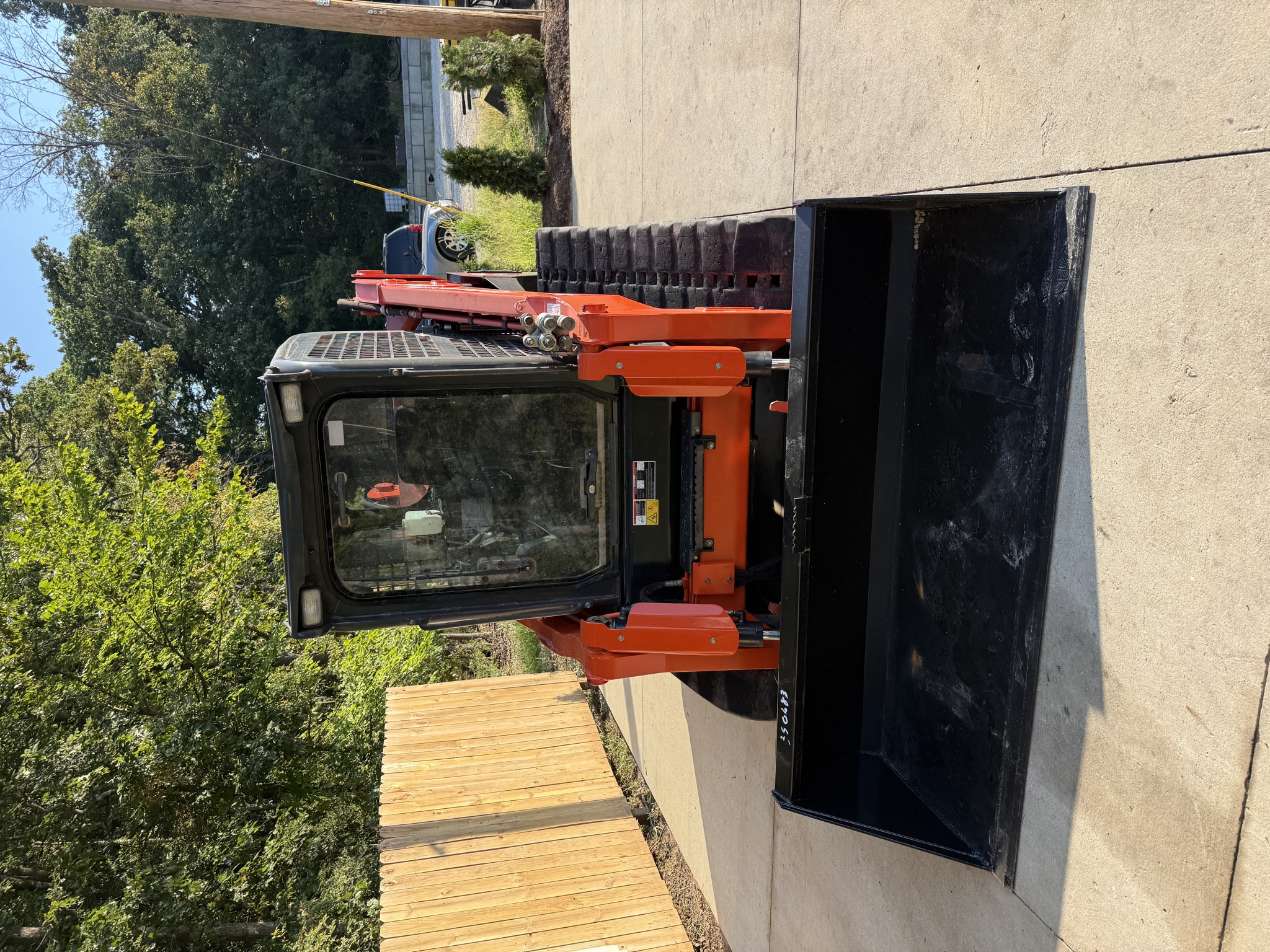Front view of the 2024 Kubota SVL97-2 enclosed cab and smooth bucket