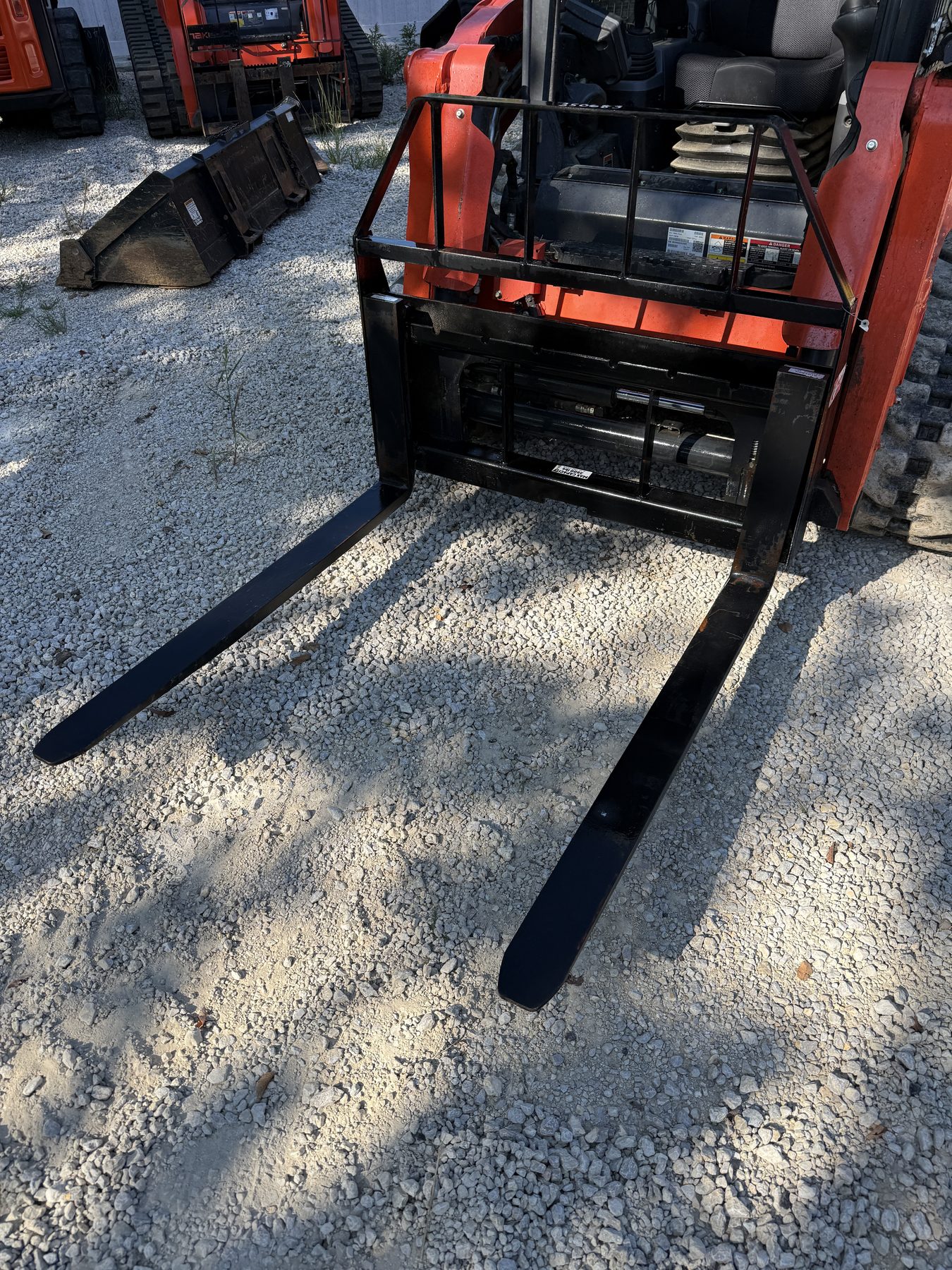 Standard pallet fork attachment mounted on a compact track loader