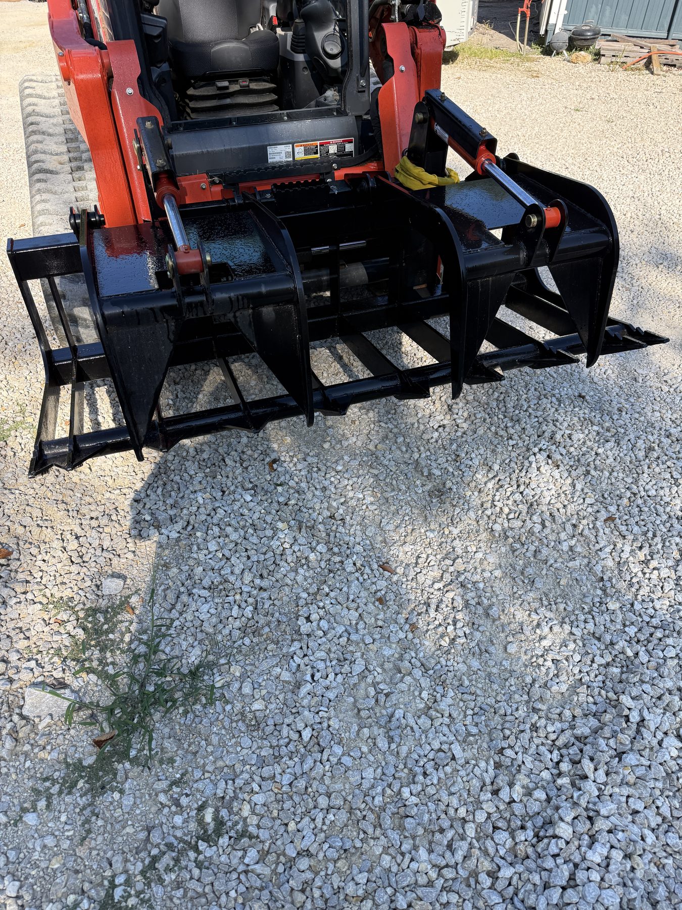 American-made root grapple mounted on a compact track loader
